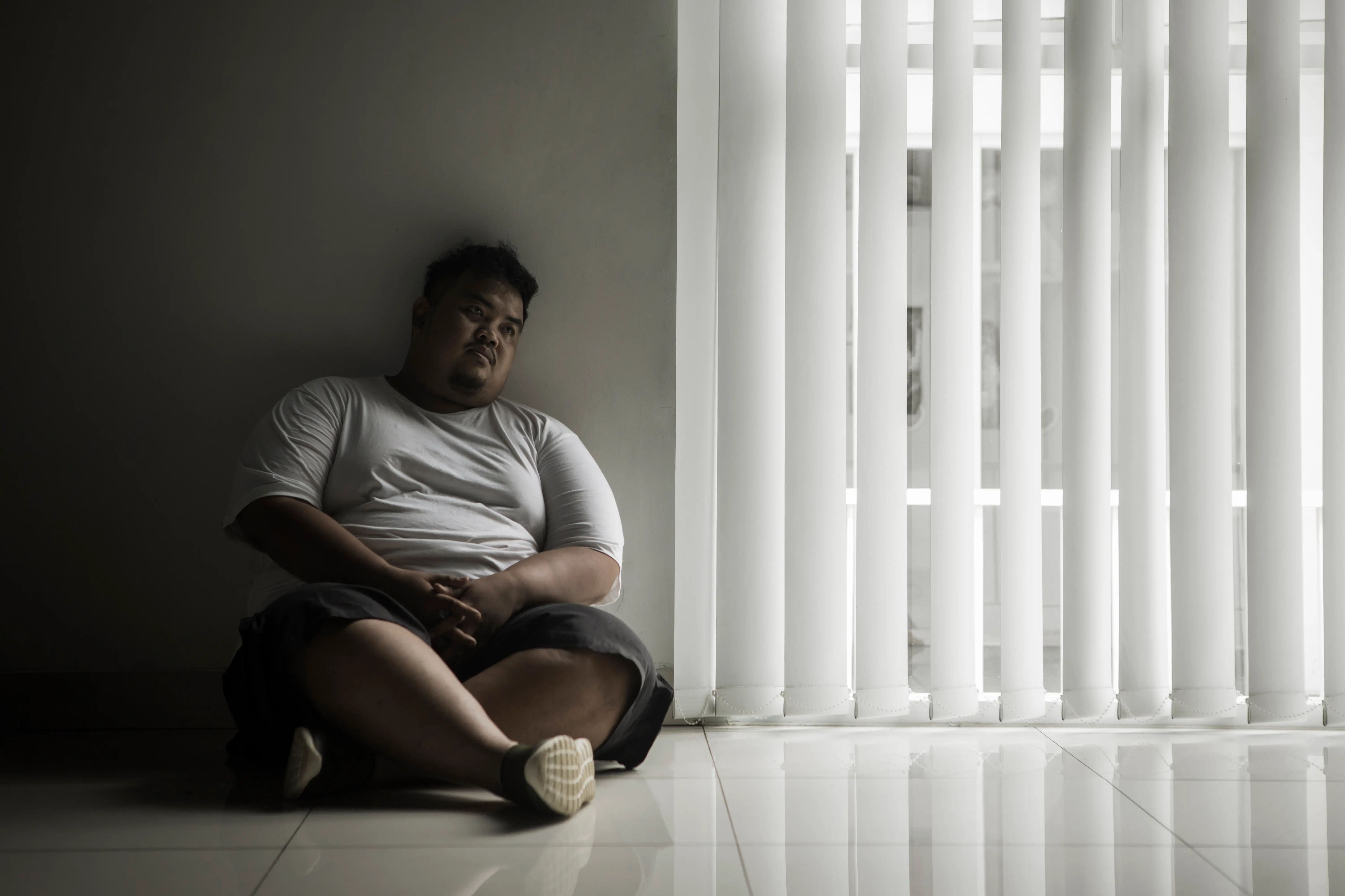 lonely-fat-man-looks-daydream-near-window